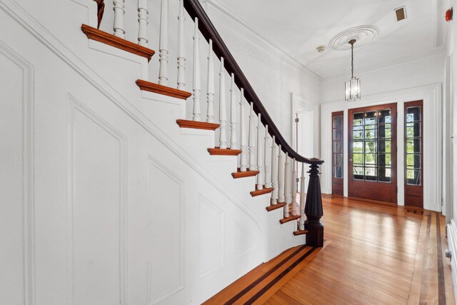 90 Main St, Chester, NY 10918 - foyer with light wood finished floors, stairway, a chandelier, ornamental molding, and baseboard heating