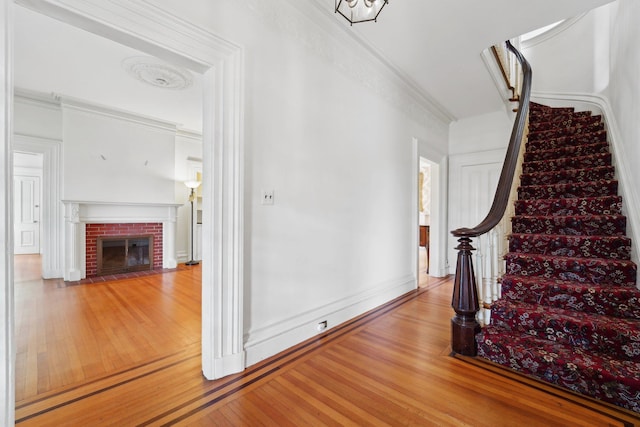 90 Main St, Chester, NY 10918 - stairs featuring wood finished floors, ornamental molding, and a brick fireplace