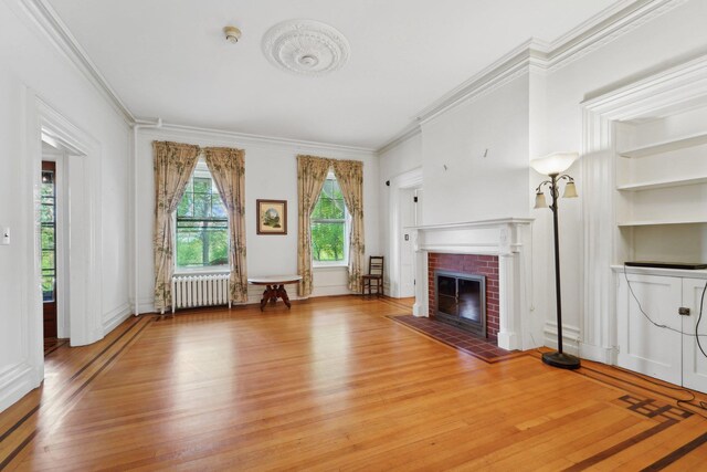 90 Main St, Chester, NY 10918 - living room with radiator, light wood-style floors, ornamental molding, a brick fireplace, and built in features