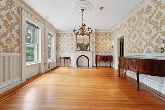 90 Main St, Chester, NY 10918 - unfurnished living room with wallpapered walls, a chandelier, light wood-style floors, wainscoting, and crown molding