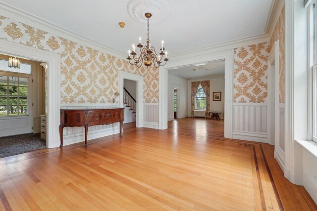 90 Main St, Chester, NY 10918 - unfurnished living room featuring a chandelier, wallpapered walls, stairs, light wood-type flooring, and wainscoting