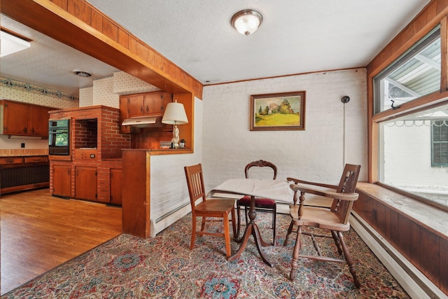 90 Main St, Chester, NY 10918 - dining space with wood finished floors, wallpapered walls, a textured ceiling, and baseboard heating