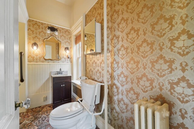 90 Main St, Chester, NY 10918 - bathroom with radiator, toilet, wallpapered walls, vanity, and a wainscoted wall