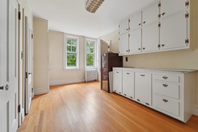 90 Main St, Chester, NY 10918 - kitchen featuring radiator, light wood finished floors, white cabinetry, baseboards, and light countertops