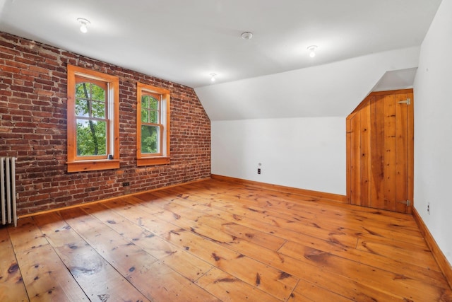 90 Main St, Chester, NY 10918 - additional living space featuring hardwood / wood-style floors, vaulted ceiling, brick wall, baseboards, and radiator heating unit