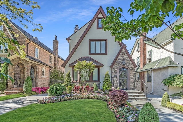148-03 9th Ave, Whitestone, NY 11357 - tudor house featuring stucco siding, stone siding, a front lawn, and a chimney