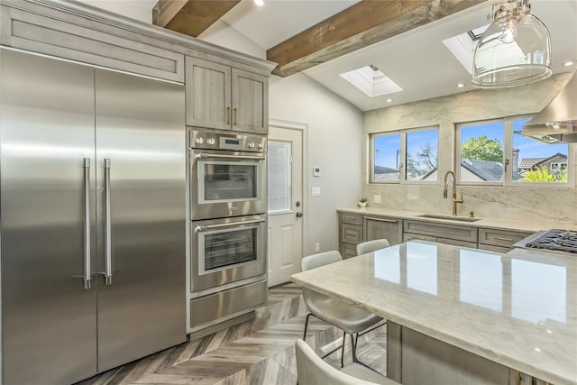 148-03 9th Ave, Whitestone, NY 11357 - kitchen featuring stainless steel appliances, a sink, a skylight, a warming drawer, and light stone countertops
