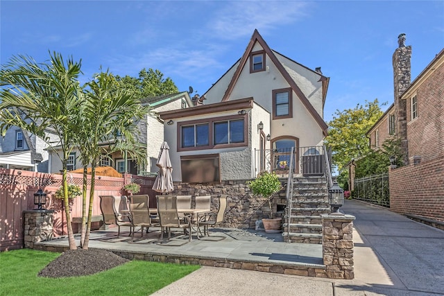 148-03 9th Ave, Whitestone, NY 11357 - rear view of house with stucco siding, a patio area, stairs, and stone siding