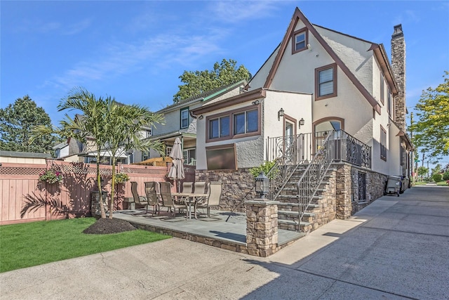 148-03 9th Ave, Whitestone, NY 11357 - view of front of house featuring stone siding, stucco siding, a patio area, and stairs