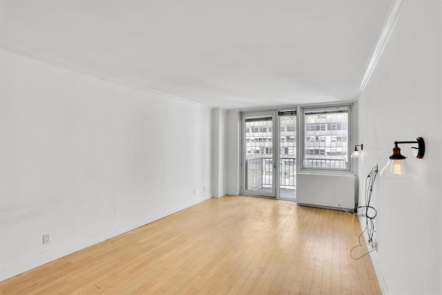 211 E 46th St Unit 14E, New York Manhattan, NY 10017 - spare room featuring ornamental molding, wood-type flooring, and baseboards
