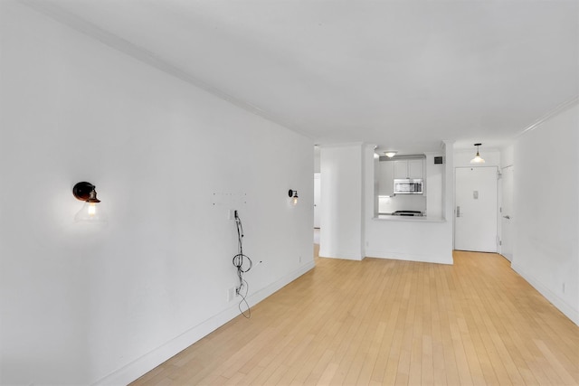 211 E 46th St Unit 14E, New York Manhattan, NY 10017 - unfurnished living room with light wood-style flooring and baseboards