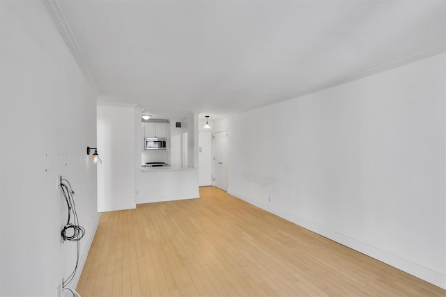 211 E 46th St Unit 14E, New York Manhattan, NY 10017 - unfurnished living room featuring ornamental molding, light wood-style flooring, and baseboards