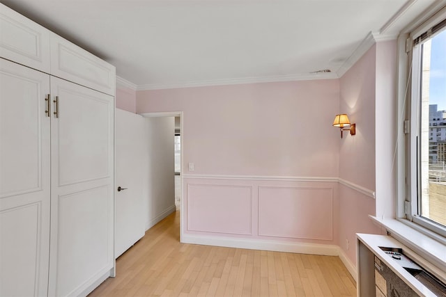 211 E 46th St Unit 14E, New York Manhattan, NY 10017 - unfurnished bedroom with light wood-type flooring, ornamental molding, wainscoting, and a closet
