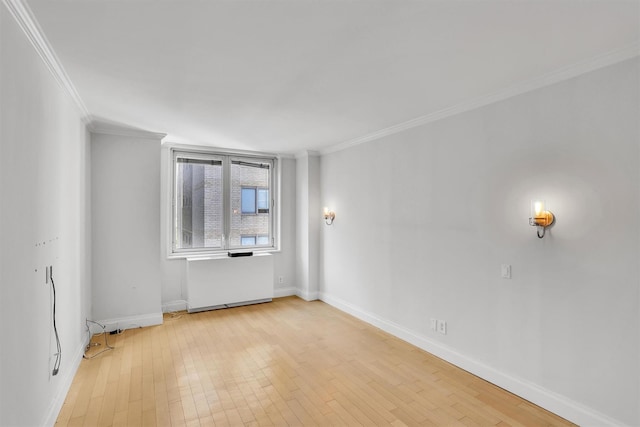 211 E 46th St Unit 14E, New York Manhattan, NY 10017 - empty room with crown molding, radiator, light wood-type flooring, and baseboards