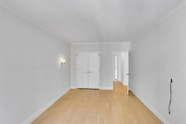 211 E 46th St Unit 14E, New York Manhattan, NY 10017 - unfurnished bedroom featuring light wood finished floors, crown molding, baseboards, and a closet