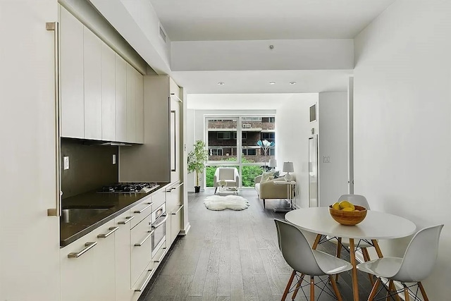 340 E 23rd St Unit 4L, New York Manhattan, NY 10010 - kitchen with dark countertops, dark wood-type flooring, stainless steel gas cooktop, and modern cabinets