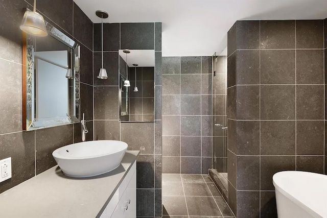 340 E 23rd St Unit 4L, New York Manhattan, NY 10010 - bathroom featuring tile walls, tiled shower, a soaking tub, and vanity