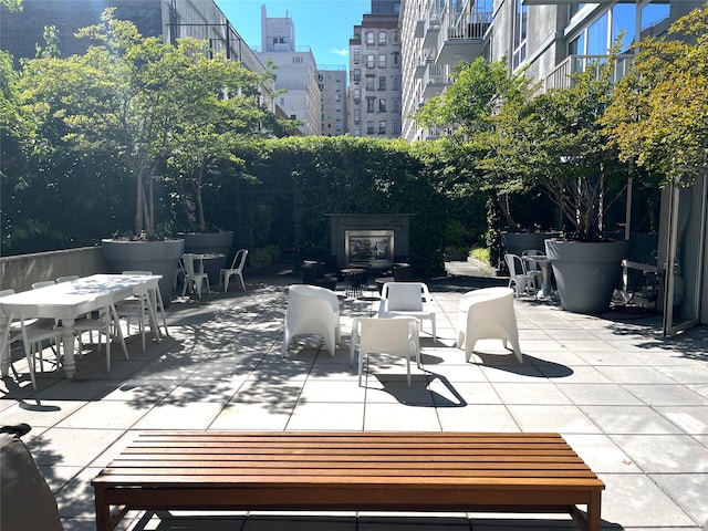 340 E 23rd St Unit 4L, New York Manhattan, NY 10010 - view of patio / terrace with outdoor dining space, a fireplace, and a city view
