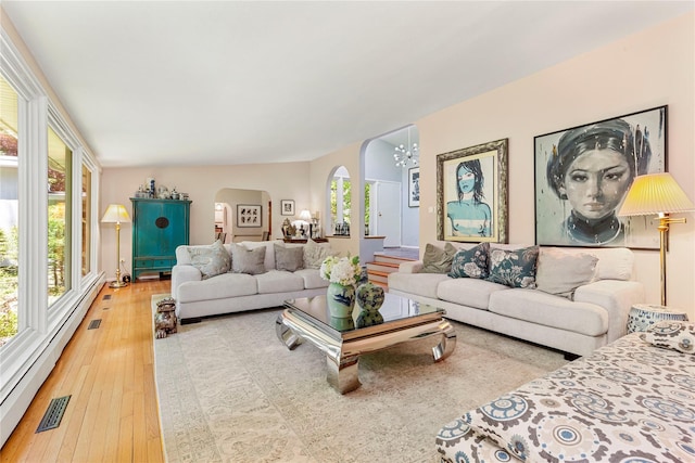 6 Harbor Hill Dr, Lloyd Harbor, NY 11743 - living room featuring arched walkways, hardwood / wood-style floors, and a baseboard heating unit