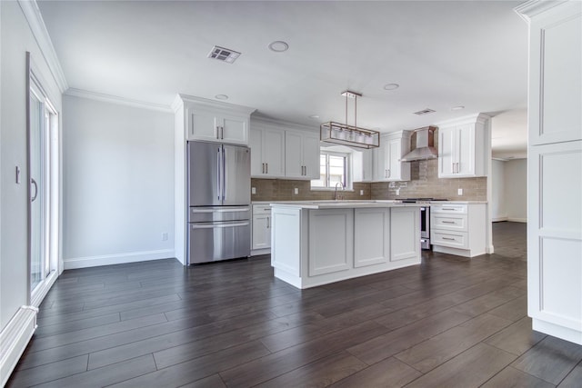 22 May Pl, Staten Island, NY 10312 - kitchen with appliances with stainless steel finishes, light countertops, wall chimney range hood, baseboards, and white cabinets