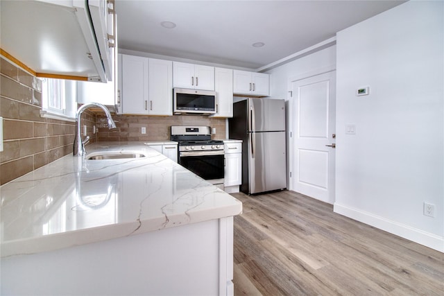 22 May Pl, Staten Island, NY 10312 - kitchen featuring stainless steel appliances, a sink, light stone countertops, tasteful backsplash, and white cabinetry