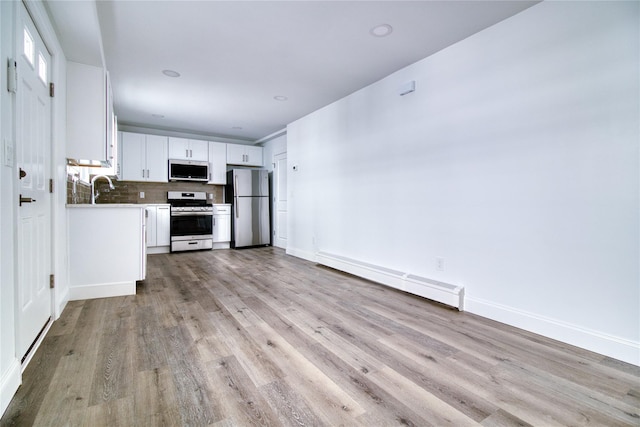 22 May Pl, Staten Island, NY 10312 - kitchen featuring appliances with stainless steel finishes, a baseboard radiator, light wood-style floors, white cabinetry, and backsplash