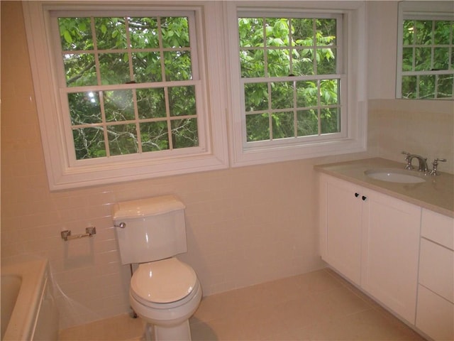 29 Carpenter Ave Unit B3, Mount Kisco, NY 10549 - bathroom with tile walls, a tub to relax in, toilet, vanity, and tile patterned floors
