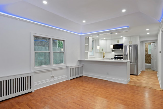 8 Lafayette Ave, Lake Grove, NY 11755 - kitchen featuring stainless steel appliances, radiator, light wood-style floors, a peninsula, and recessed lighting