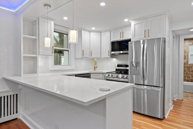 8 Lafayette Ave, Lake Grove, NY 11755 - kitchen with stainless steel appliances, a sink, a peninsula, white cabinets, and light stone counters