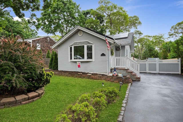 8 Lafayette Ave, Lake Grove, NY 11755 - bungalow-style house with roof mounted solar panels, a gate, asphalt driveway, and roof with shingles
