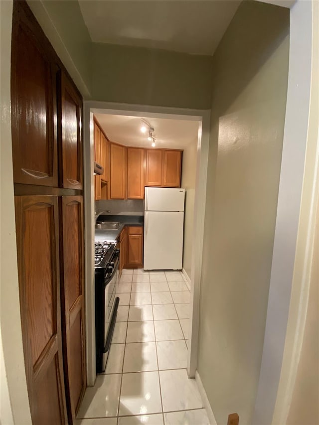 70-25 Yellow Stone Blvd Unit 10Z, Forest Hills, NY 11375 - kitchen featuring freestanding refrigerator, black gas range oven, light tile patterned floors, dark countertops, and a sink