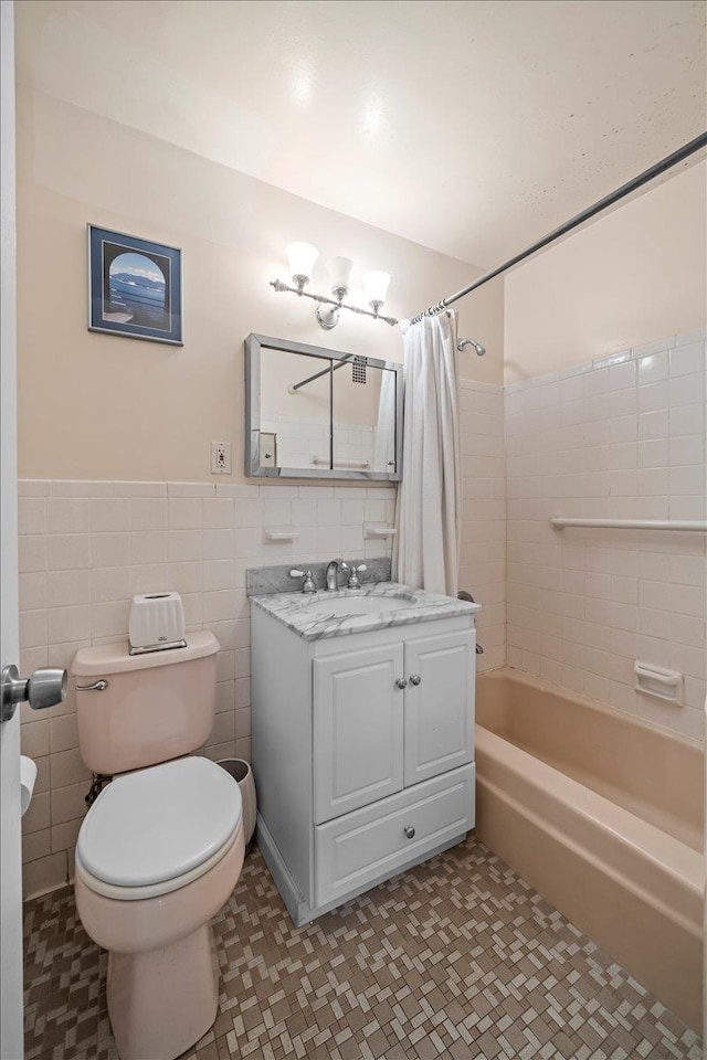 555 Kappock St Unit 17D, Bronx, NY 10463 - full bathroom with vanity, shower / bath combo with shower curtain, toilet, tile walls, and a wainscoted wall