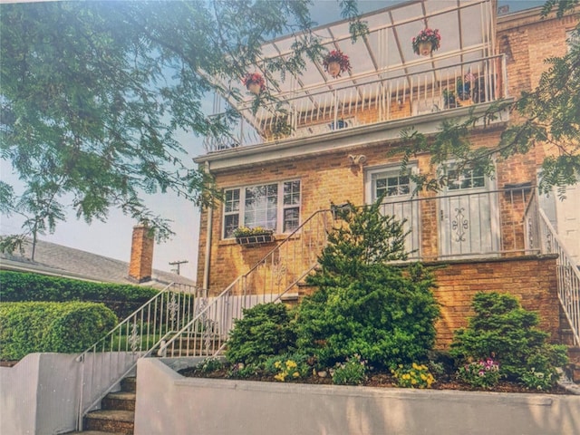 133-50 123rd St Unit 2, South Ozone Park, NY 11420 - view of front of house with stairway, brick siding, and a balcony