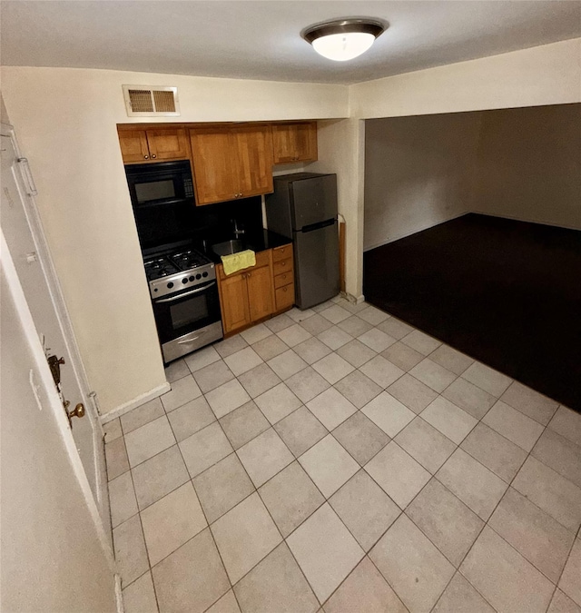 105-24 64 Unit 4L, Forest Hills, NY 11375 - kitchen featuring black microwave, stainless steel gas stove, freestanding refrigerator, brown cabinets, and light tile patterned flooring