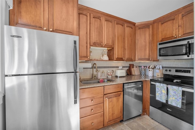 2B Kings Unit 2B, Mohegan Lake, NY 10547 - kitchen featuring appliances with stainless steel finishes, light stone countertops, tasteful backsplash, and brown cabinetry