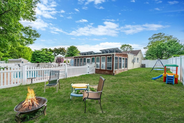 25 Biscayne Dr, Selden, NY 11784 - view of yard with a sunroom, a fire pit, a playground, a pool, and central air condition unit
