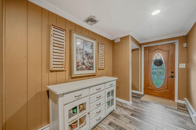 25 Biscayne Dr, Selden, NY 11784 - foyer entrance featuring a baseboard heating unit, ornamental molding, light wood-style floors, wood walls, and baseboards