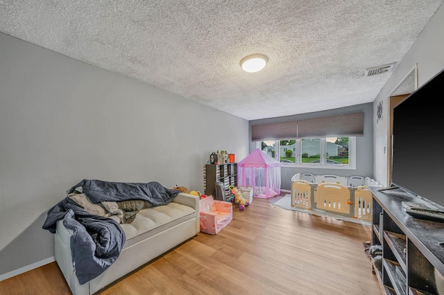 25 Biscayne Dr, Selden, NY 11784 - playroom featuring wood finished floors, a textured ceiling, and baseboards