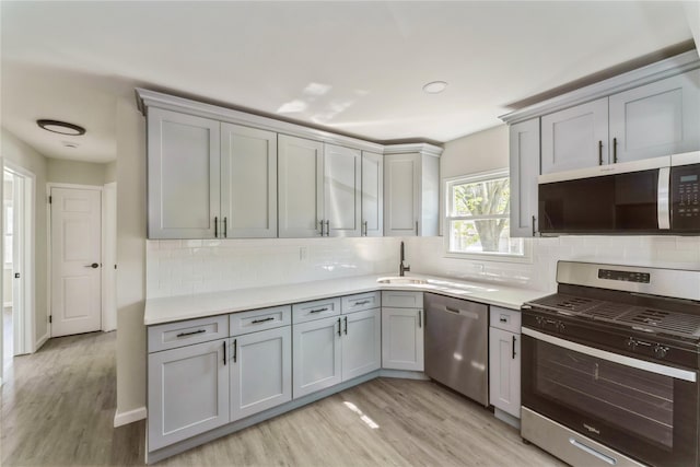 183-19 145th Ave, Springfield Gardens, NY 11413 - kitchen featuring stainless steel appliances, gray cabinetry, light countertops, and light wood-style floors