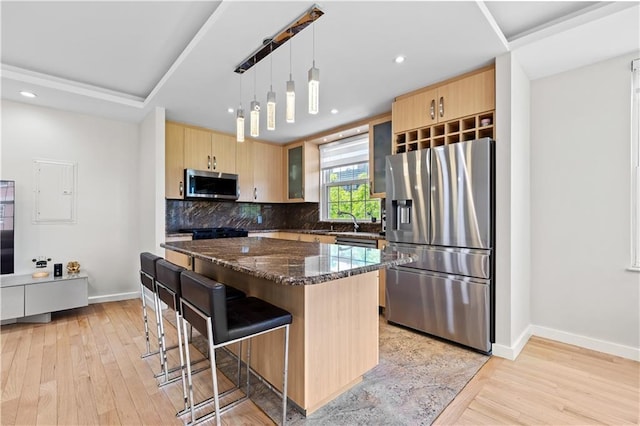 150 Oceana Dr W Unit 4B, Brooklyn, NY 11235 - kitchen featuring appliances with stainless steel finishes, light brown cabinets, a breakfast bar, light wood-style flooring, and recessed lighting
