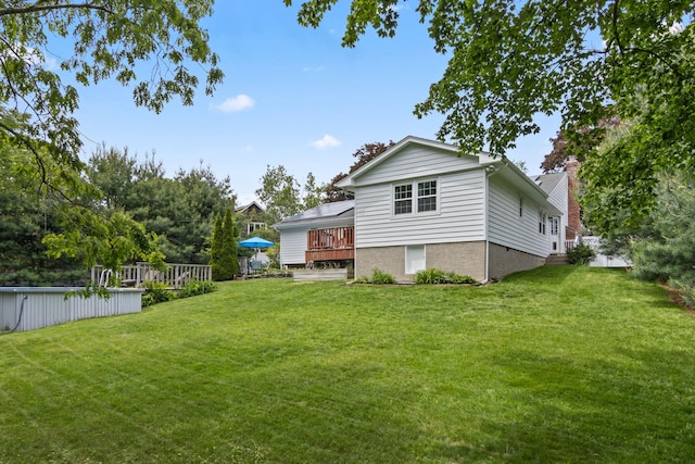 18 Chivalry Ln, Nesconset, NY 11767 - rear view of property featuring a deck, a lawn, a swimming pool, and a chimney
