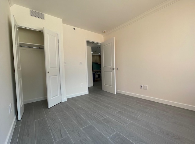 132-27 41st Rd Unit 4A, Flushing, NY 11355 - unfurnished bedroom featuring dark wood-style flooring, baseboards, crown molding, and a closet