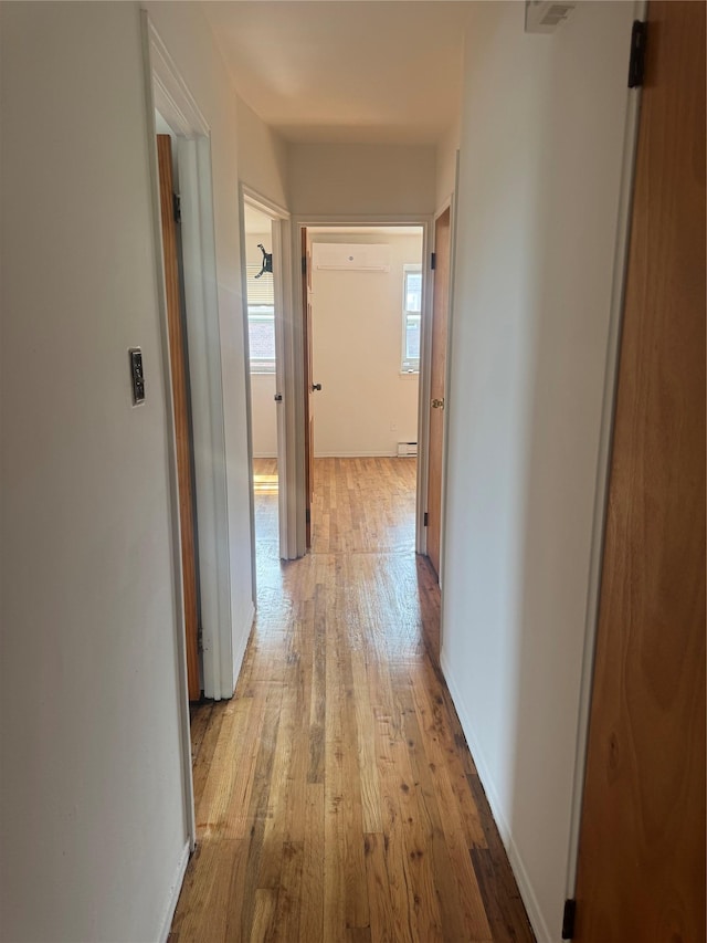 25-72 127th St, Flushing, NY 11354 - hall with light wood-style flooring, an AC wall unit, and a baseboard radiator