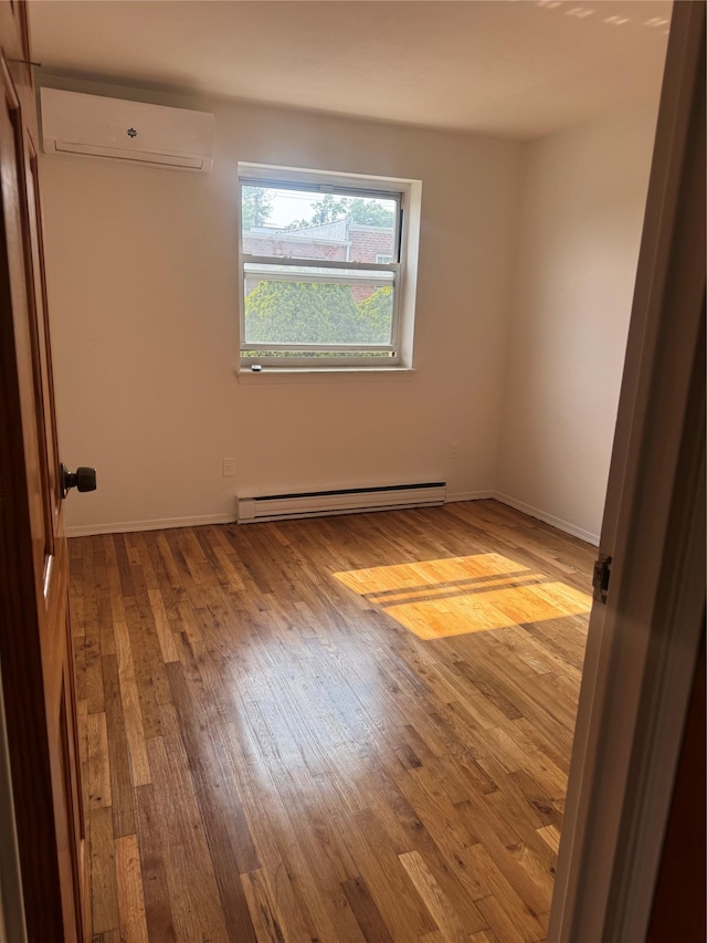 25-72 127th St, Flushing, NY 11354 - unfurnished room with an AC wall unit, baseboard heating, and wood finished floors