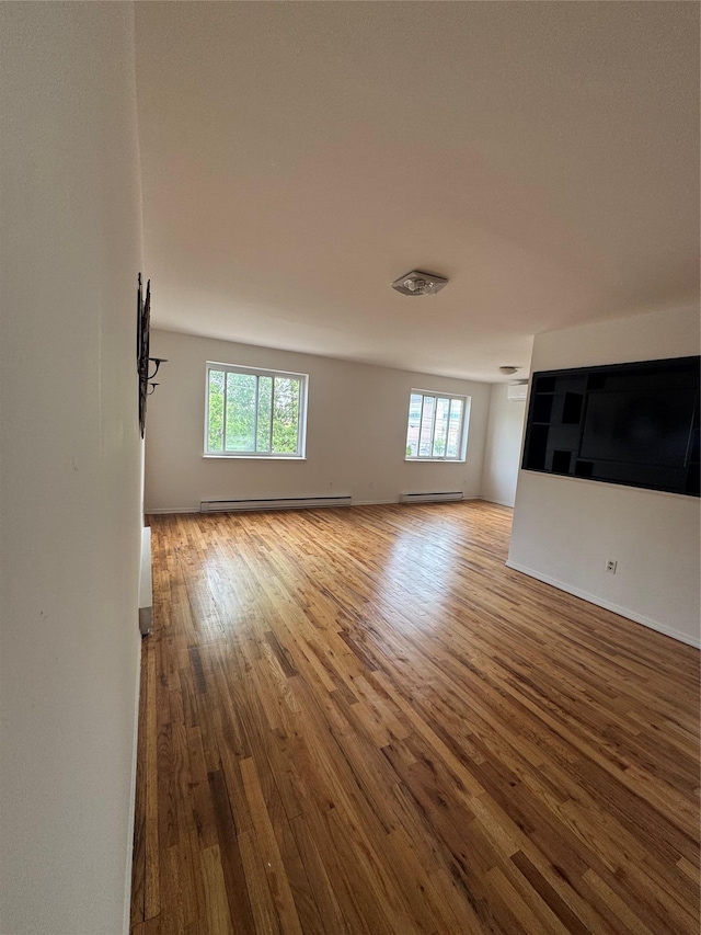 25-72 127th St, Flushing, NY 11354 - unfurnished living room featuring a baseboard radiator and wood finished floors