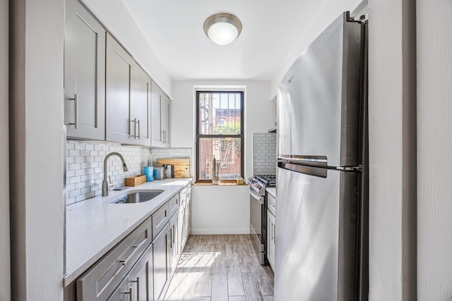 219 Berry St Unit 2, Brooklyn, NY 11249 - kitchen featuring appliances with stainless steel finishes, a sink, gray cabinets, tasteful backsplash, and light wood-style flooring