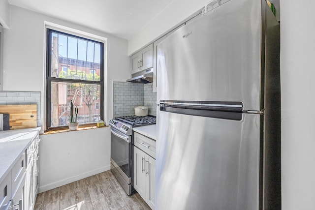 219 Berry St Unit 2, Brooklyn, NY 11249 - kitchen with stainless steel appliances, under cabinet range hood, light countertops, and decorative backsplash