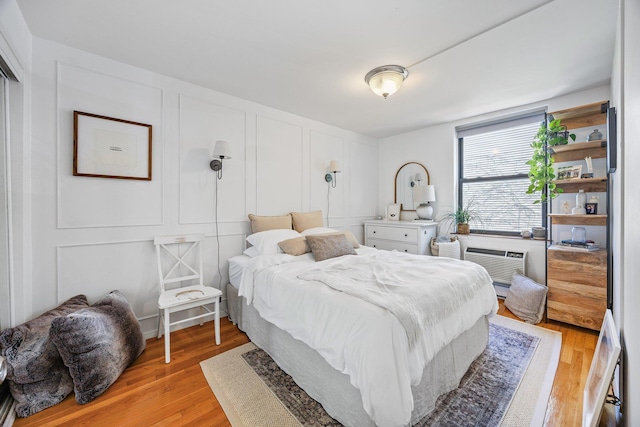 219 Berry St Unit 2, Brooklyn, NY 11249 - bedroom with a decorative wall, light wood-style floors, and a wall mounted AC