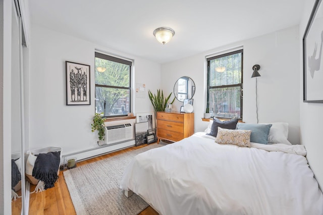 219 Berry St Unit 2, Brooklyn, NY 11249 - bedroom featuring multiple windows, baseboard heating, wood finished floors, and a wall unit AC