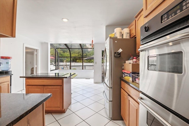 204 Carnation Dr, Farmingdale, NY 11735 - kitchen featuring appliances with stainless steel finishes, light tile patterned flooring, dark stone counters, and a center island
